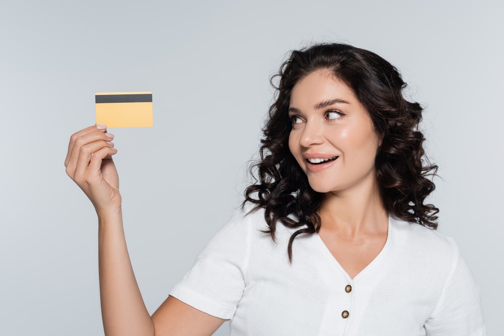 nainen pitelee luottokorttia
